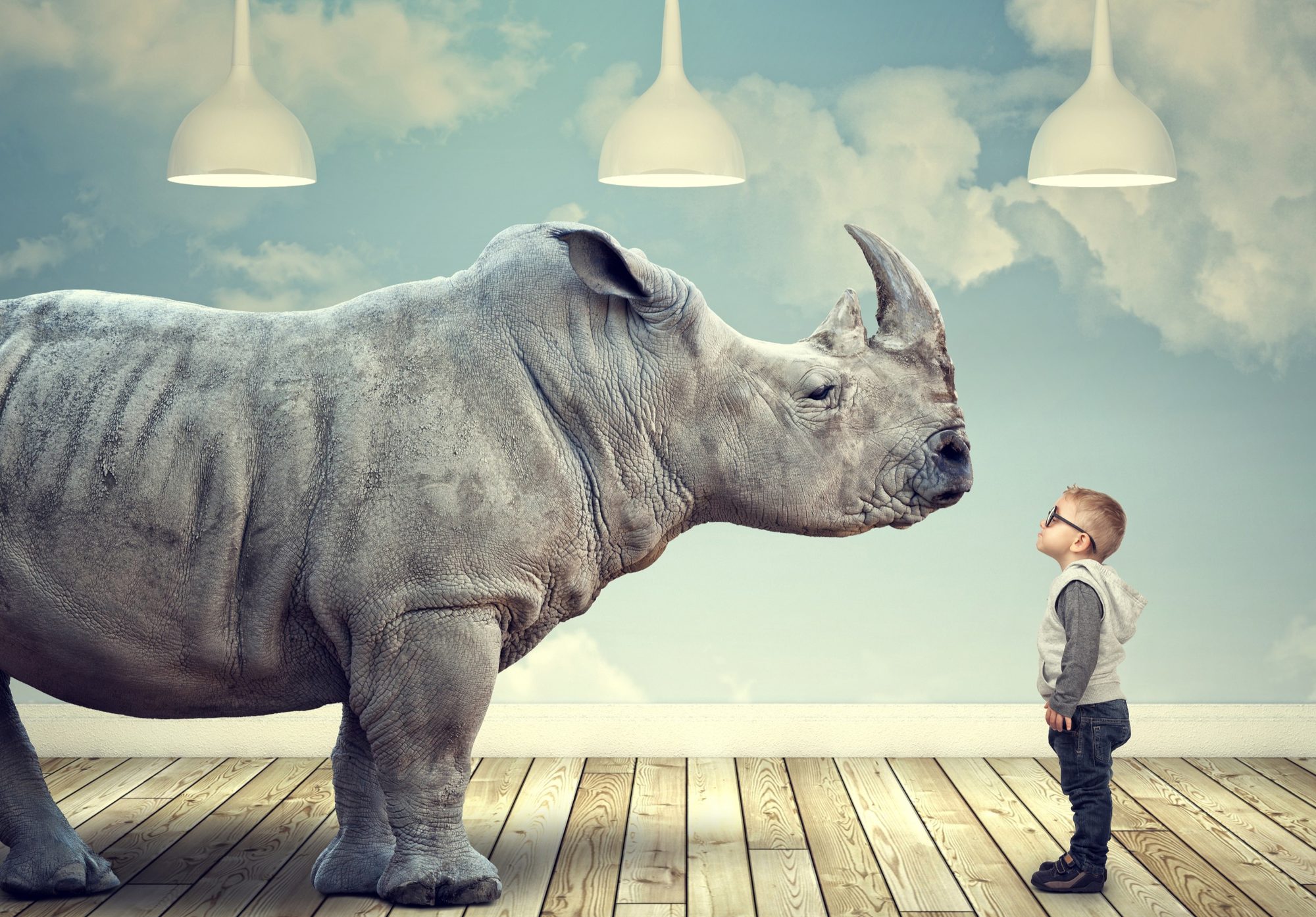 Ein Nashorn steht vor einem kleinen Jungen